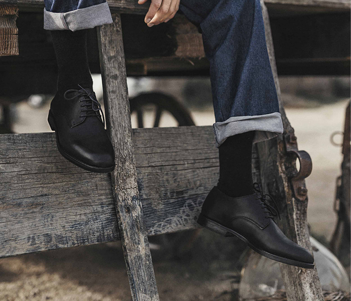 paire de derby noir en cuir porté - paire de chaussure de ville noire en cuir homme porté - idées tenues chaussure de ville - derby et jean - derby camargue - la botte gardiane derby en cuir homme - derby en cuir noir homme porté
